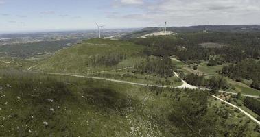 Wind Turbines On The Lush Mountains Generating Renewable Energy In Reguengo Do Fetal, Batalha, Portugal - aerial drone, pullback shot video