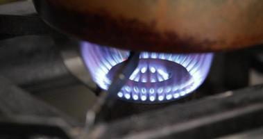 estufa encendida con llama azul ardiendo debajo de la olla - cerrar video