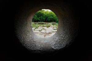 vista interior de un dolmen de piedra a través de un agujero en un bosque de montaña en el valle del río jean foto