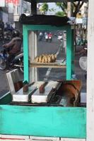 pastel de pancong atau kue gandos vendedor en la carretera foto
