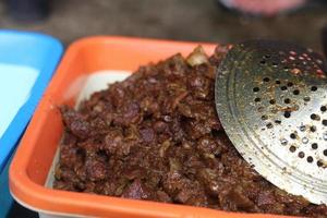processed goat meat on an orange plastic container. photo
