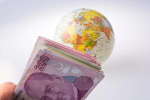 billetes de lira turca al lado de un globo modelo foto