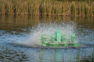 Water treatment concept. Aerator turbine wheel fill oxygen into water, high shutter speed captures multiple water splash,select focus with shallow depth of field. Wastewater treatment conservation. photo