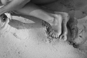 Cerrar chica descalza en la playa concepto monocromo foto