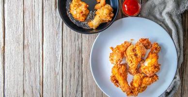 Fried chicken food and french fries on a wooden table photo