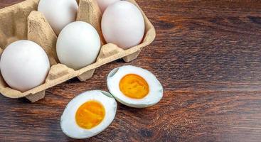 huevos de pato blanco y comida de huevo salada en una mesa de madera