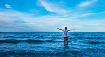 The boy Standing in the middle of the ocean waves. Feeling brave challenge, adventure, and courage concept photo