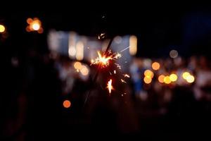 Festive background, bengal light on the dark background, New Year with sparklers sparks on a festive background. selective focus. photo