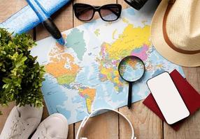 Flat lay traveler accessories on map, camera, glasses, digital devices