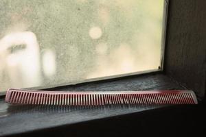 An old comb putting near the window photo