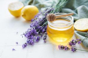 tarro con miel y flores frescas de lavanda foto