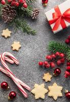 Christmas background with gingerbread cookies, gift boxe and fir branches  on darck concrete background. photo