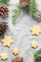 rama de pino y galletas navideñas sobre un fondo textil foto