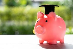 Save money coins in piggy bank and graduation cap, Business finance education concept. photo
