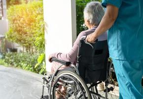 Caregiver help and care Asian senior or elderly old lady woman patient sitting in wheelchair on ramp at nursing hospital, healthy strong medical concept photo