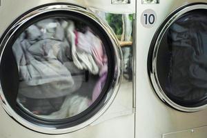 movimiento de cierre borroso de la ropa girando dentro de la máquina seca en la tienda de lavado foto