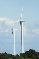 windmills stand against a blue cloudy sky photo