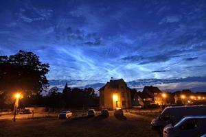 Nubes noctilucentes extremadamente brillantes y raras en la ciudad el 21 de junio de 2019 en una noche de verano en Alemania foto