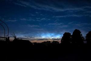 fuertes nubes noctilucentes al amanecer sobre Alemania después de la puesta del sol en el verano foto