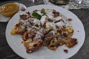 typical austrian food called Kaiserschmarrn on a wooden table in the alps photo