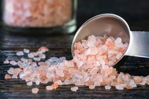 cristales de sal marina del himalaya derramados de una cucharadita foto