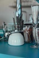 Empty glasses of various shapes and small teapots on the bar counter in a restaurant or cafe. Details of the modern interior in cafe. photo