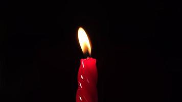 Red wax candle light on black background video