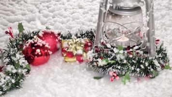 Christmas lantern and garland decoration with winter snow falling at slow motion video