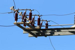 Wires on a pole carrying high voltage electric current. photo
