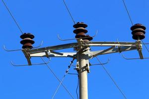 Wires on a pole carrying high voltage electric current. photo