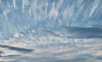 Sky with cirrus and stratus clouds, contrasting daytime background of nature, weather change, sunset photo