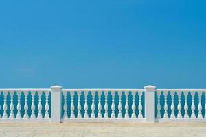 Summer view with classic white balustrade and empty terrace overlooking the mediterranean sea, vacation idea. Free space for text photo