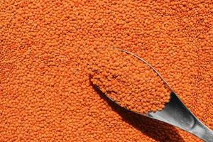 Vegetarian nutritional product - red lentils, vegetable protein, ingredient for soups layout on the table, top view. Idea for a banner and product advertisement, a backdrop for a recipe article photo