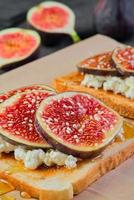 Close-up on toast with figs, honey and ricotta cheese sprinkled with sesame seeds, vertical frame. Selective focus on sandwich, breakfast idea or photo for menu, mediterranean breakfast