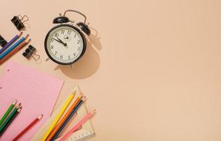 Ready to go back to school, school subjects on a light flesh-colored background. Notepads, pens, pencils, alarm clock and other tools. Banner with place for text. photo
