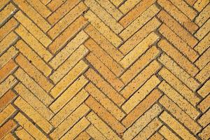 Idea of simple wallpaper for your desktop is pattern with rectangular tiles made of yellow bricks in the form of herringbone. Diagonal texture, abstract background of old brick ceramic cobblestone photo