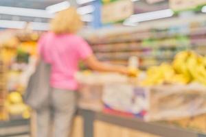Blurred market background with woman silhouette next to rows of fruit shelves, ready idea for postcard or website design. Mockup for a banner in the office or advertising photo