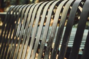 Abstract background, a bench made of metal bars in the park, the idea of a background or screensaver for an article about travel and the urban environment photo
