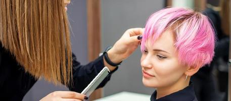 Young woman receiving short pink hairstyle photo