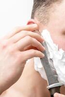 Man shaving beard with knife photo