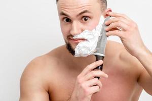 hombre afeitándose la barba con un cuchillo foto