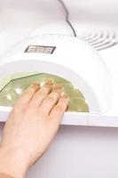 Process for drying of nails with UV lamp machine photo