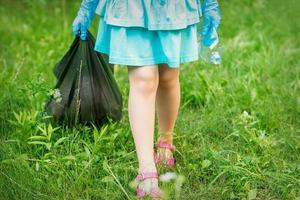 niña con botella de plástico arrugada foto