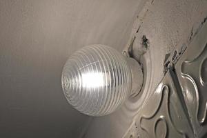 Old glass lamps in the basement. Lighting devices under the shelf. Lighting in a white room. photo