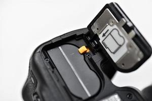 The battery of the SLR camera. Changing the camera battery in close-up. The camera battery is in the photographer's hand. photo