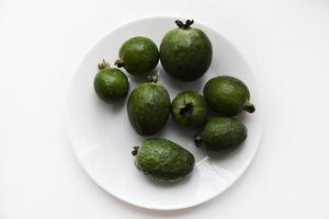 Green feijoa fruits close-up on a white background. Beautiful feijoa fruits. photo