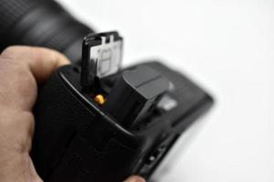 The battery of the SLR camera. Changing the camera battery in close-up. The camera battery is in the photographer's hand. photo