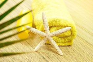 estrella de mar blanca con toalla amarilla envuelta en una tumbona de paja con palmera. turismo, viaje foto