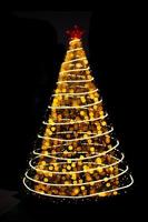 Blurred yellow Christmas tree lights with particles and circles on black isolated background. Design element. Defocused spruce with star. Overlay. New Year photo