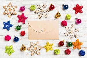 Top view of envelope on festive wooden background. Christmas toys and decorations. New Year time concept photo